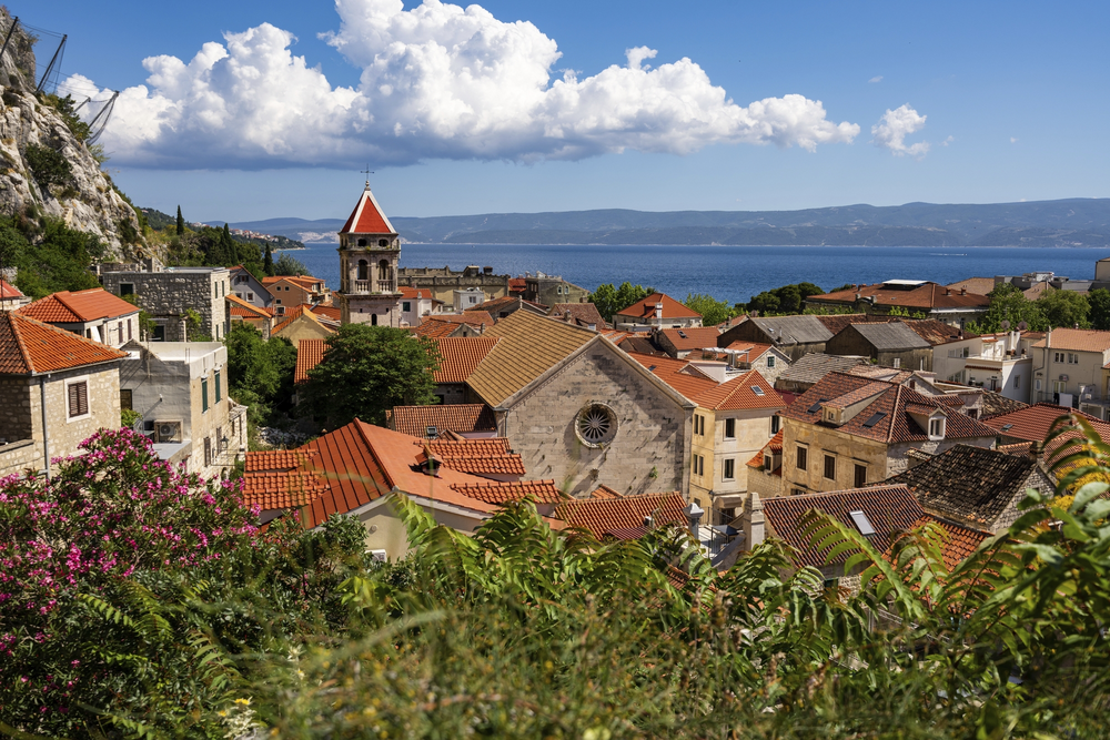 Kirche der Stadt und im Hintergrund das Meer und die Berge der Nachbarinsel