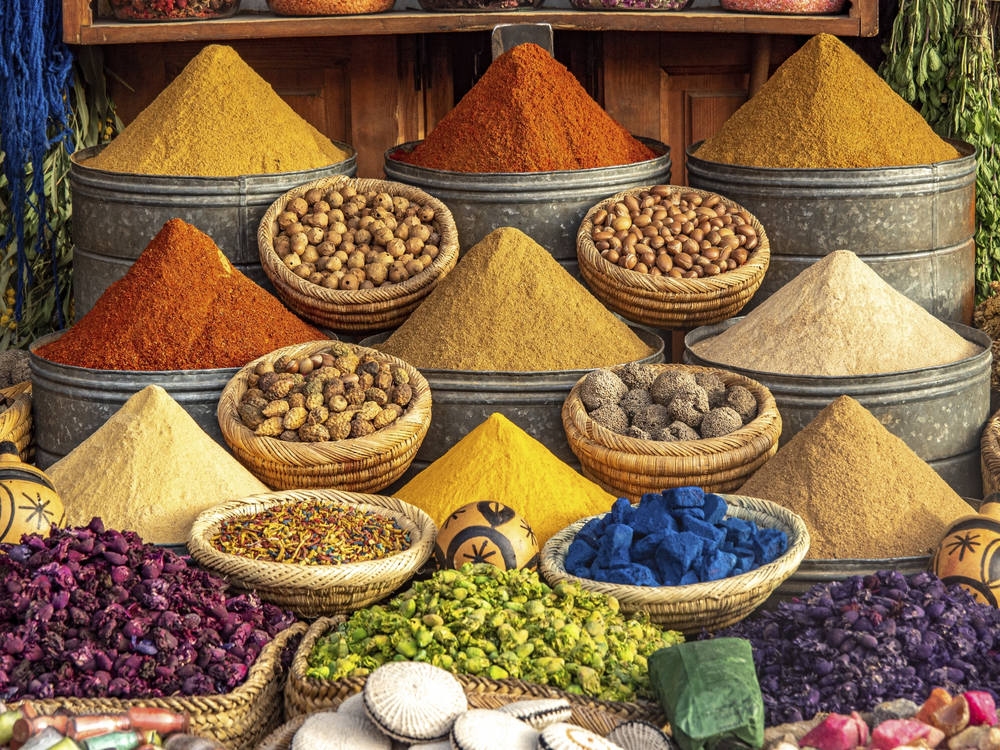 Gewürzstand in Marrakesch mit pyramidenförmig aufgeschichteten Gewürzen, Nüssen und getrockneten Zutaten in verschiedenen Farben