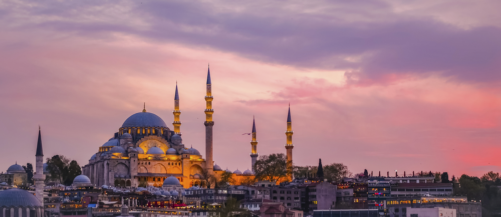 Sultan-Ahmed-Moschee in Istanbul bei Sonnenuntergang mit Kuppeln und Minaretten vor einem rosa-violetten Abendhimmel
